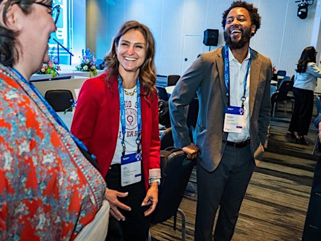 Three attendees talk at the Illuminate 2023 networking reception